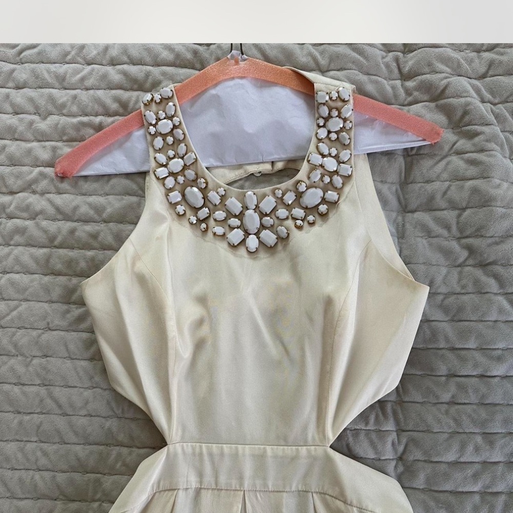 Elegant Cream Sleeveless Dress with Embellished Neckline